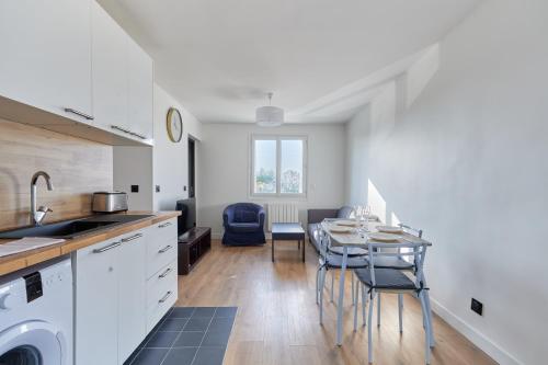 une cuisine et une salle à manger avec une table et des chaises dans l'établissement Appartement Lumière Normande - Welkeys, à Cabourg