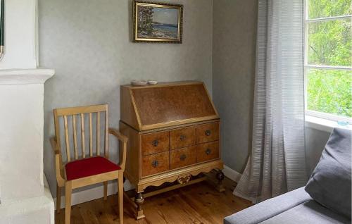 a wooden dresser in a room with a chair at 5 Bedroom Gorgeous Home In Edsbruk in Edsbruk