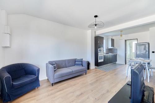 un salon avec deux canapés et une cuisine dans l'établissement Appartement Sérénité Normande - Welkeys, à Cabourg