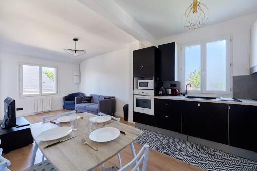 - une cuisine et un salon avec une table en bois dans la chambre dans l'établissement Appartement Sérénité Normande - Welkeys, à Cabourg