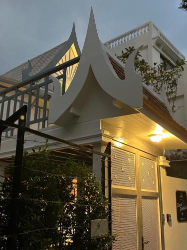 a white house with a gate and a railing at Baan Debtida in Bangkok
