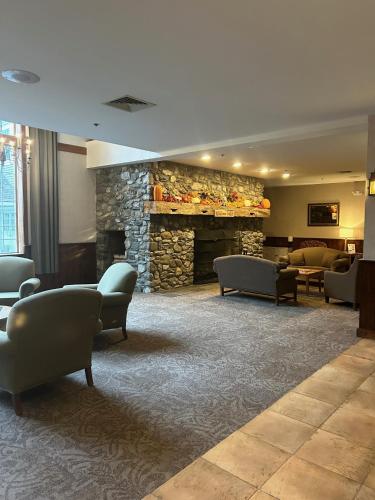 a lobby with chairs and a stone fireplace at Jiminy Peak Mountain Resort in Hancock