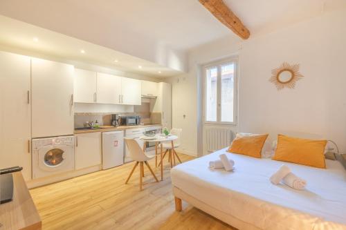 une chambre avec un grand lit et une cuisine dans l'établissement Studio Azurite - Welkeys, à Antibes