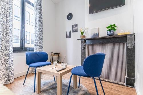 a living room with two blue chairs and a table at Beautiful Serenity Stylish Shared Apt at Ghent's Central in Ghent