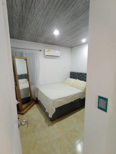 a small room with a bed and a mirror at Apto Marbella in Cartagena de Indias