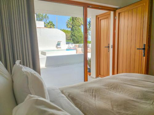 ein Schlafzimmer mit einem Bett und Blick auf ein Badezimmer in der Unterkunft Villa Esperança in Porches