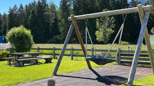 a swing and a picnic table in a park at Pension Edelweiß Mitterberg in Mitterberg