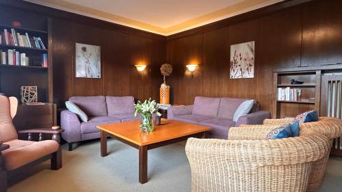 a living room with purple couches and a table at Pension Edelweiß Mitterberg in Mitterberg