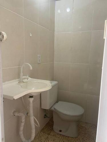 a bathroom with a sink and a toilet at Casa com Piscina - Área da lazer familiar in Guarujá