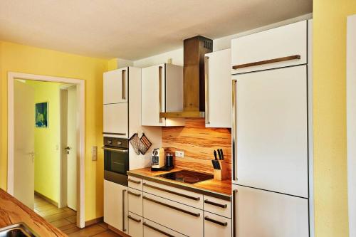 a kitchen with white cabinets and a white refrigerator at A plus Ferienpark Usedom in Ostseebad Koserow