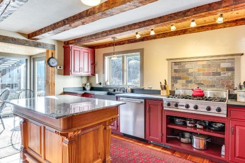 a kitchen with red cabinets and a stove top oven at Outdoor Fireplace and Pool Table Tamworth Home! in Tamworth