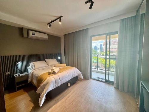 a bedroom with a bed and a large window at 512 - Rentaqui Studio no Brooklin Sofisticação in Sao Paulo