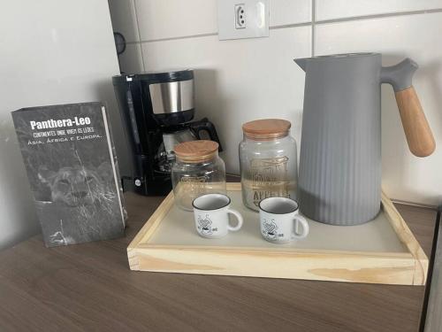two cups of coffee sitting on a cutting board with a blender at Apartamento Madero in Umuarama