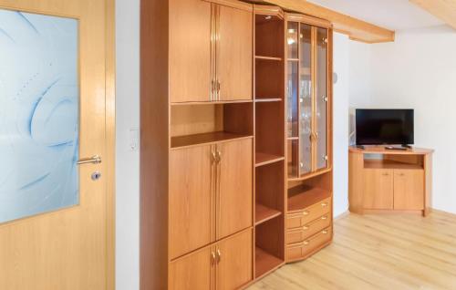 a closet with wooden cabinets and a television at Awesome Home In Wies With Wifi in Wies