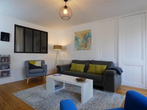 un salon avec un canapé et une table dans l'établissement Belle époque, à Granville