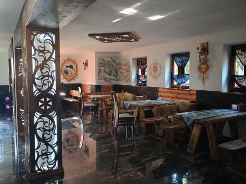 a restaurant with wooden tables and chairs in a room at Pokoje Gościnne U Moniki i Daniela in Zakopane