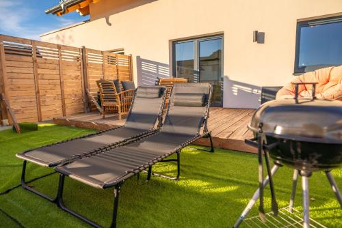 a grill and chairs on a lawn next to a grill at Höhenweg Appartement & Ferienwohnung in Mariapfarr