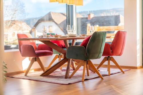 a dining room table with four chairs and a window at Höhenweg Appartement & Ferienwohnung in Mariapfarr