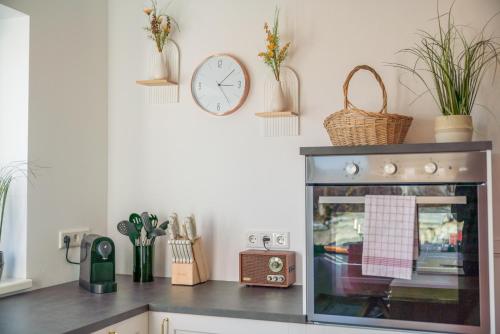 a kitchen with a clock on the wall and a counter at Höhenweg Appartement & Ferienwohnung in Mariapfarr