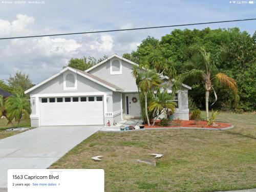 a white house with a white garage at Punta Gorda Home, Sleeps 10 in Punta Gorda