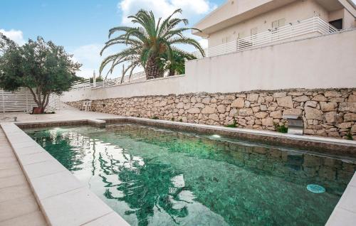 ein Schwimmbad vor einem Gebäude in der Unterkunft Gorgeous Home In Marina Di Ragusa in Marina di Ragusa