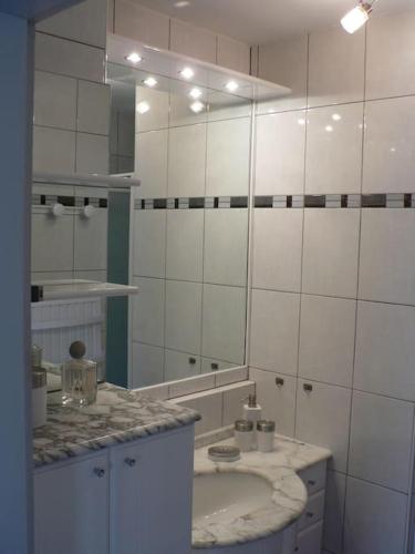 une salle de bain avec un lavabo et un miroir dans l'établissement La Maison d'Anne, à Ribeauvillé