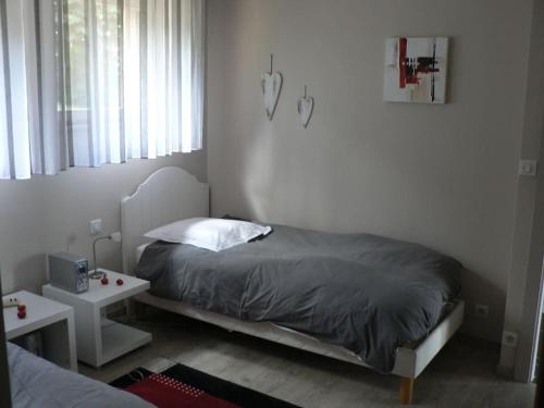 Un dormitorio pequeño con una cama y una ventana. en La Maison d'Anne, en Ribeauvillé