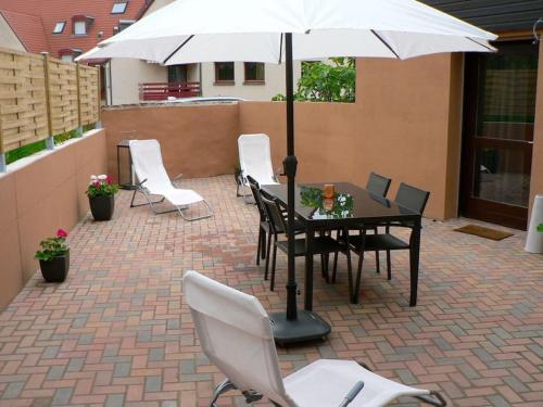 Un patio con una mesa y sillas y una sombrilla. en La Maison d'Anne, en Ribeauvillé