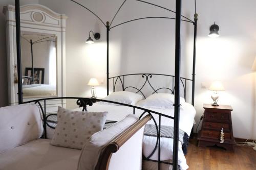 - une chambre avec un lit à baldaquin noir et un miroir dans l'établissement Typical farm with private pool close to the Ventoux 8 persons, à Althen-des-Paluds