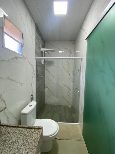 a bathroom with a toilet and a glass shower door at Pousada do Nativo in Fernando de Noronha