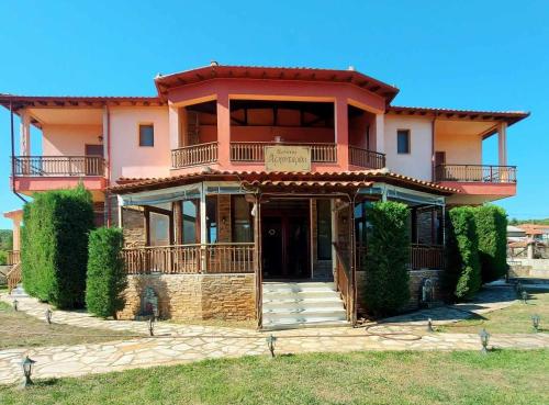 a large house with a balcony on top of it at Xenonas Arxontariki in Mikrón Dhérion