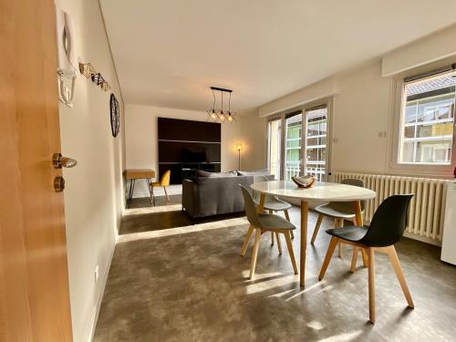 une salle à manger et un salon avec une table et des chaises dans l'établissement Les Violettes, bel appartement au centre-ville, à Gérardmer