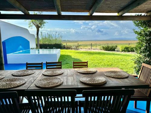 a wooden table with chairs and a view of a yard at Comporta - Wood & Blue in Comporta