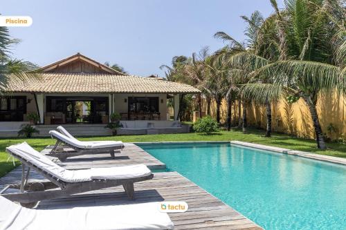 a swimming pool with two lounge chairs and a house at Paraíso de Luxo à Beira-mar no Fortim in Maceio