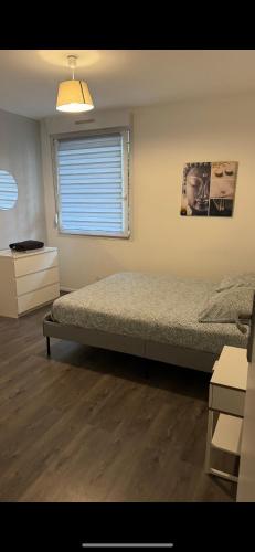 - une chambre avec 2 lits et une fenêtre avec un store dans l'établissement F2 cosy proche marché de Noël, à Schiltigheim