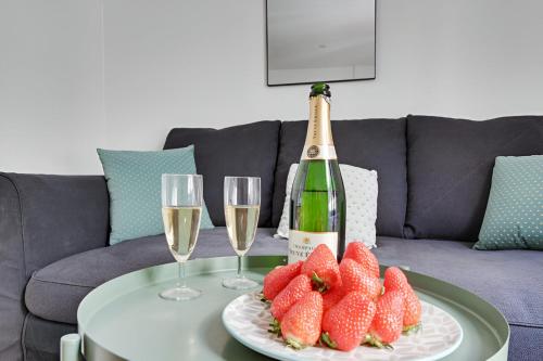 - une bouteille de champagne et une assiette de fraises sur une table dans l'établissement 137-Suite Ella Great 1 BDR APT centre de Paris, à Paris