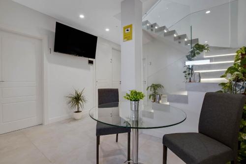 a dining room with a glass table and chairs at CAMINITO REY & BANDERAS SPA Relax in Carratraca