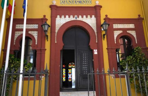 a red and yellow building with a black door at CAMINITO REY & BANDERAS SPA Relax in Carratraca