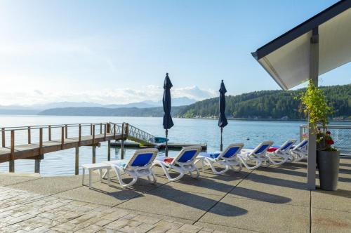 a row of chairs and umbrellas next to a dock at Walls of Glass Hood Canal Vacation Rental in Union