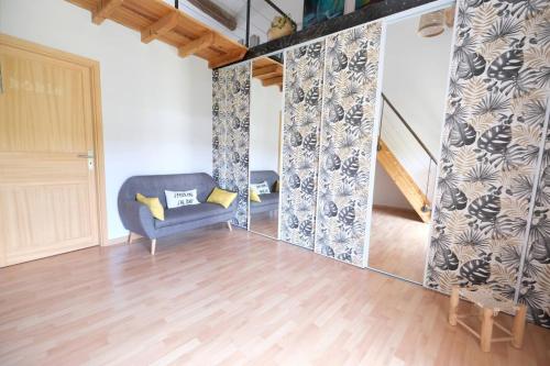 a living room with a blue chair and a staircase at beautiful provencal mas with pool in barbentane, close to avignon, sleeps 8. in Barbentane