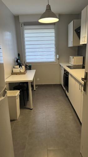 une cuisine vide avec une table et une fenêtre dans l'établissement F2 cosy proche marché de Noël, à Schiltigheim