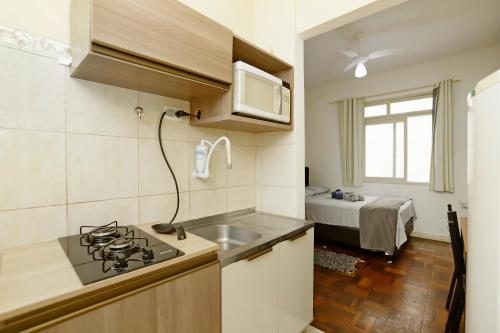 a kitchen with a sink and a stove top oven at Espaço inteiro no Centro Histórico, bem localizado in Porto Alegre