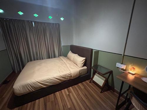 a small bedroom with a bed and a desk at The Aurum Motel - self check-in - in Alor Setar