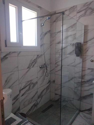 a bathroom with a shower with a glass door at Chios Cozy Apartment 2 in Sklaviá