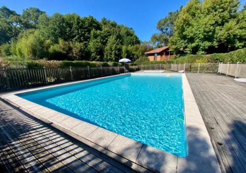 une piscine avec de l'eau bleue dans une cour dans l'établissement Evasion Nature, proxy Océan et forêt, à Messanges
