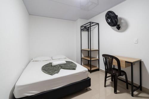 a bedroom with a bed and a chair and a desk at Hotel Doxa in Medellín