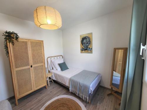 a small bedroom with a bed and a mirror at Pleasant detached villa with private swimming pool for 6 people in Lauris - Luberon. in Lauris