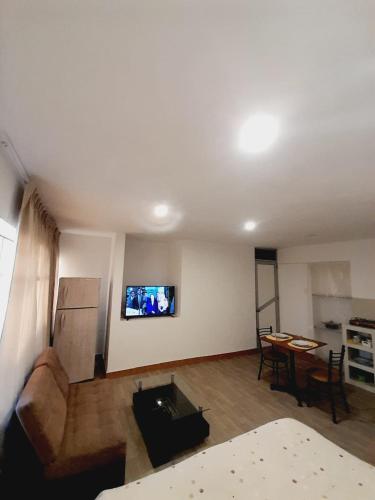 a living room with a couch and a tv on the wall at DEPA CAMa QUEEN in Huancayo