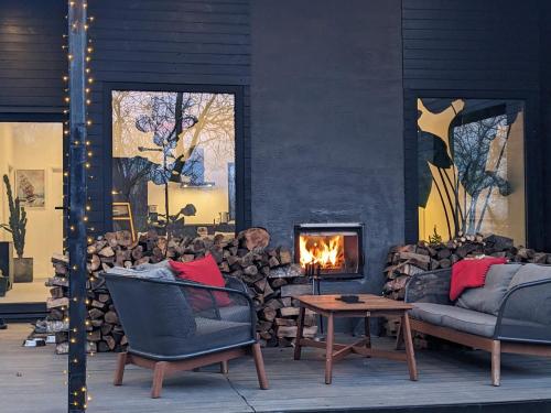a living room with two chairs and a fireplace at Black Walnut House with indoor outdoor fireplace in Izvoarele