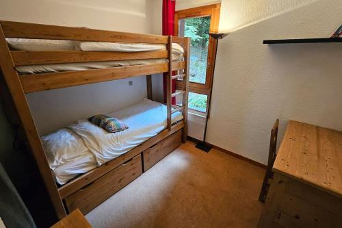 une chambre avec deux lits superposés et une fenêtre dans l'établissement Bel appartement 3 chambres plein sud, à Bourg-Saint-Maurice